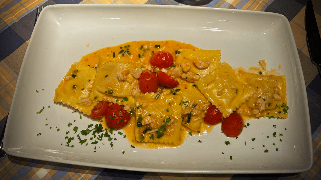 Primo piatto di pesce: Ravioli di crostacei, capesante, gamberetti, zucchine e pomodorini
