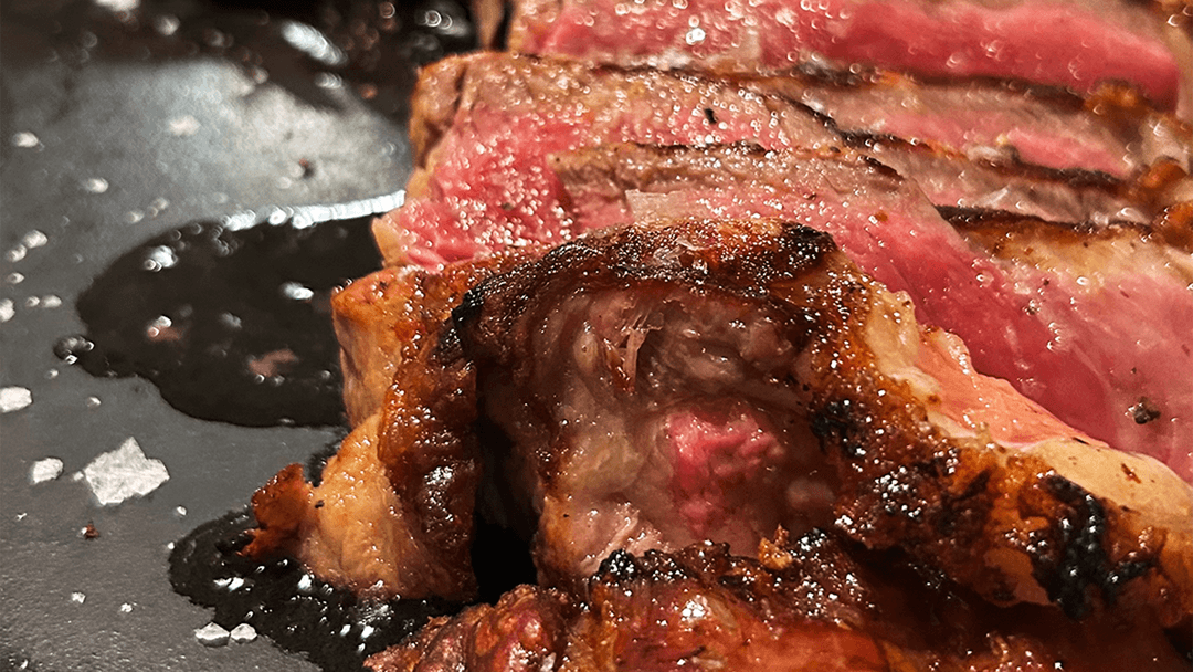 Costata di carne Sashi alla griglia servita al sangue su piatto caldo da Osteria Therra a Mirano, specialità gourmet per amanti della carne pregiata.